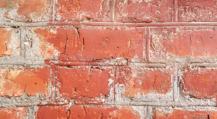 Red brick wall with cracks and scratches. Old background texture. Vintage house facade.