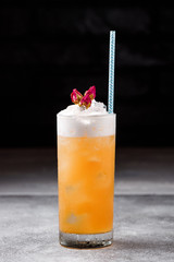 orange cocktail with ice and cream on a dark background. cocktail bar menu concept.