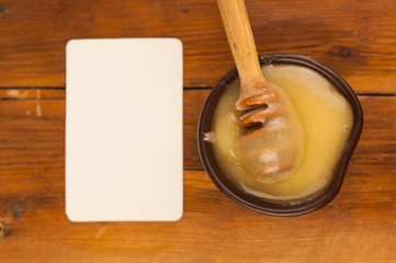 honey pour from a wooden spoon into a clay plate