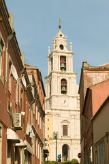 Fototapeta na wymiar Narrow streets leading to church and bell tower of Mafra, Portugal