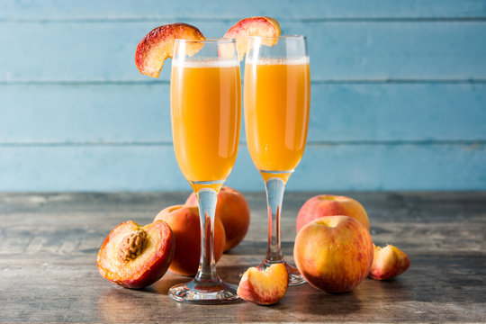 Bellini champagne cocktail in crystal glass on blue wooden table	