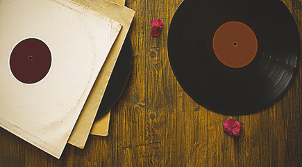 Old vinyl records (discs) on wooden background. Nostalgia.