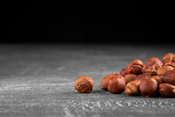 Side view closeup on the hazelnuts on the grey scratched background, horizontal format