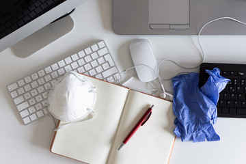 Medical mask and gloves on the desktop. Remote work and study. Telework, freelance. Notepad with place for text and pen for notes. Layout. Desktop, workspace for working at home. Office background