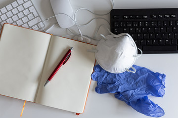Medical mask and gloves on the desktop. Remote work and study. Notepad with place for text and pen for notes. Layout. Desktop, workspace for working at home. Office background