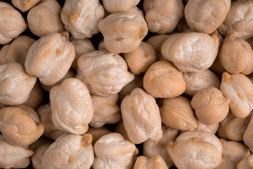 Top view closeup macro on raw uncooked chickpeas on the grey background, horizontal format