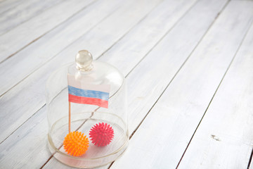 Ball in the form of a model of coronavirus Covid-19 and the Russian flag under a glass cover. America's Emergency Regime Due to COVID-19 Pandemic