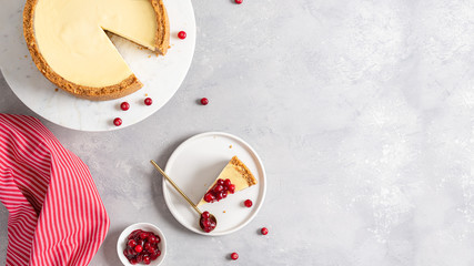 New York cheesecake banner. Classic cheesecake with cranberry sauce on marble stand and a piece of cake on the plate. Bakery, confectionery banner. Copy space, top view