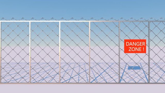Attention! Dangerous zone! A metal grill with barbed wire approaches the camera against the sky.