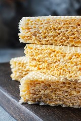Waffle cake made of crispy waffle cakes with boiled condensed milk on a gray background. Quick sweet dessert.