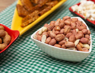 several bowls with  peanuts  and popcorn on the table