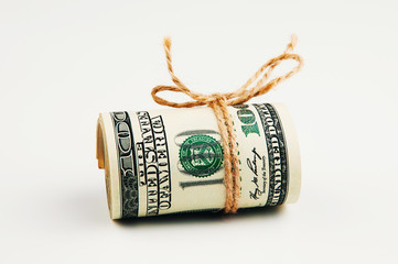 Isolated roll of dollars. A large roll of hundred-dollar bills lies on a white background