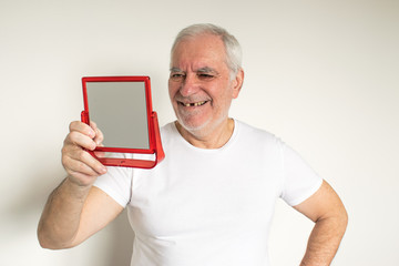 old man senior face closeup missing tooth smile proper tooth looking mirror overexposed not in focus