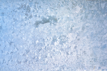 Abstract and fantastic icy patterns on frozen window glass. Hoarfrost effect texture. Blue winter background. Clear frosty ornament on surface. Christmas or winter backdrop. Rime or frost structure