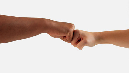 fist clash between male hand and female hand with different skin tones on white isolated