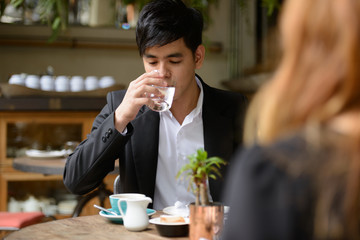 Young Asian business couple together at the coffee shop