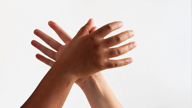 arm wrestling between male hand and female hand with different skin tones on white