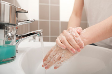 Washing hands with soap under the faucet with water for coronavirus prevention, hygiene to stop spreading coronavirus. Hygiene concept, Hygiene sanitary, clean, wash, disinfect hygienic human.