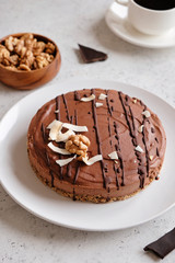 Homemade chocolate raw vegan cake - healthy dessert made from coconut milk, butter, cashew, cacao, walnut
