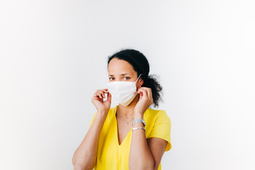 black woman putting on a surgical mask