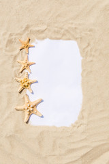 Frame with starfish on golden sandy beach. Summer vacation concept with copyspace for text message