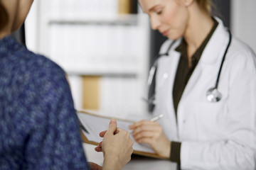 Doctor and patient discussing current health examination while sitting in clinic. Perfect medical...