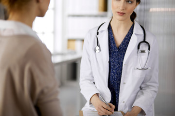 Doctor and patient discussing current health examination while sitting in clinic. Perfect medical...