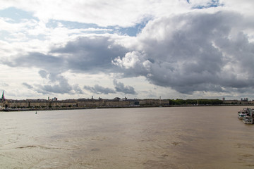 Fototapeta na wymiar Panorama sur Bordeaux depuis la Garonne par un temps nuageux