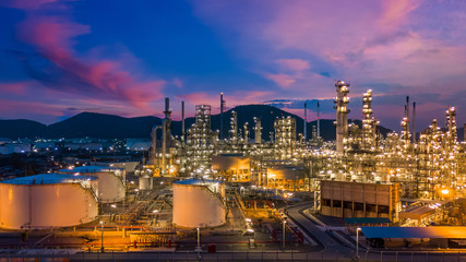 Naklejka premium Oil and gas refinery plant and storage tank form industry zone at twilight, Aerial view oil and gas Industrial petrochemical fuel power and energy.