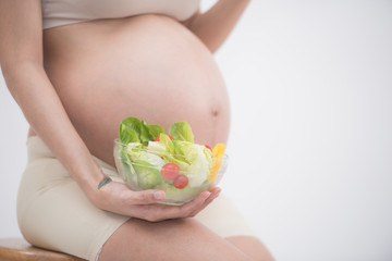 care about unborn child. pregnancy, healthy food and people concept, happy pregnant woman eating...