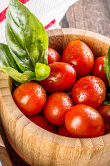 cherry tomatoes with basil in rustic wooden bowls