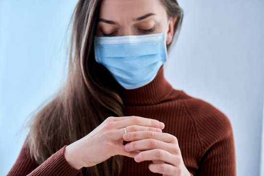 Woman In Protective Mask Remove Ring From Finger. Break Up Relationship And Divorce After Living Together During Quarantine And Isolation Due To Coronavirus Covid Epidemic. Divorce Concept
