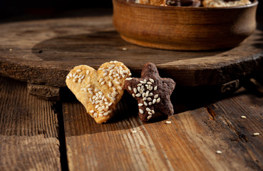 Homemade cookies with with sesame seeds in a wooden plate on a wooden background. Homemade food.