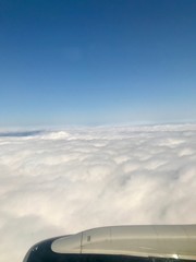 Fototapeta na wymiar Beautiful heavens gate high above the clouds: Idyllic aerial view from a airplane window with a lovely light blue sky & fluffy white clouds in the atmosphere gives a feeling of freedom
