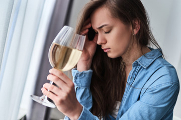 Young upset sad depressed stressed drinking woman suffers from a hangover and headache. Female...