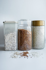 pasta, oat and buckwheat in glass jars on a white background