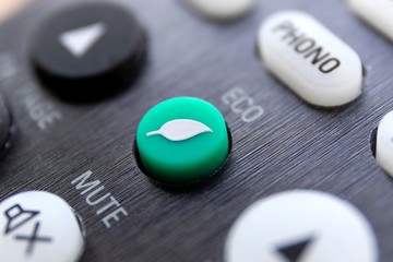 A close up portrait of an eco button on a remote control to turn a device into its ecologic...