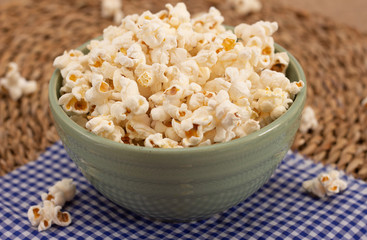 big bowl full of popcorn   on the straw background