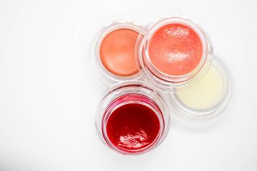 A top down view of gorgeous lip and cheek makeup products in small glass pots 