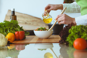 Unknown human hands cooking in kitchen. Woman is busy with vegetable salad. Healthy meal, and vegetarian food concept
