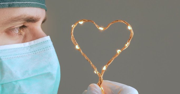 Medico chirurgo guarda il simbolo del cuore