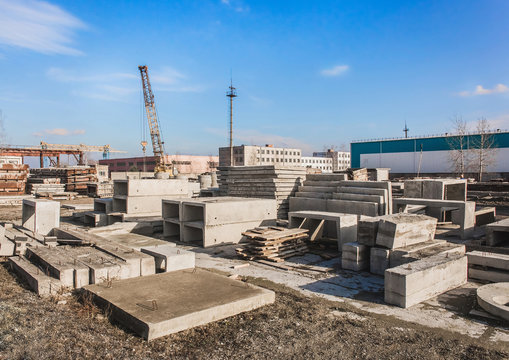 Concrete blocks at a construction site. Concrete structures in an industrial area against a blue sky with clouds