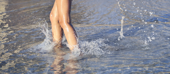 Child legs on the beach. Summertime concept.