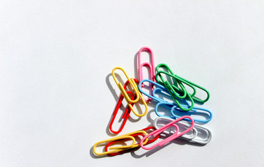colored paper clips on white background