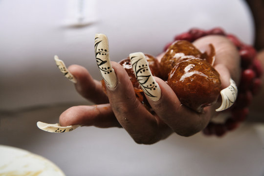Hand with large painted nails hold typical Cuban sweets