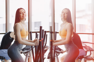 young attractive girl at gym on exercise bike, fitness and yoga
