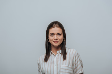 Fototapeta premium Attractive woman smiling at camera isolated on grey