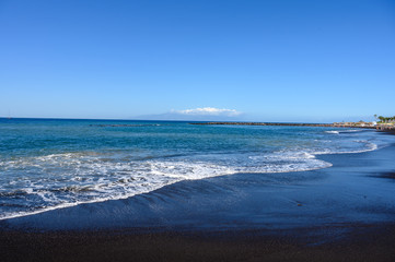 Fototapeta na wymiar All year sun vacation destination, blue ocean water on beach Playa del Duque in Costa Adeje, Tenerife island, Canary, Spain