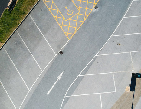 parking bay and disable parking bays from above photographed in an urban setting with a drone. lines and pattern street road markings. straight lines and geometric. drone photography above