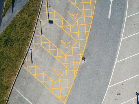 parking bay and disable parking bays from above photographed in an urban setting with a drone. lines and pattern street road markings. straight lines and geometric. drone photography above